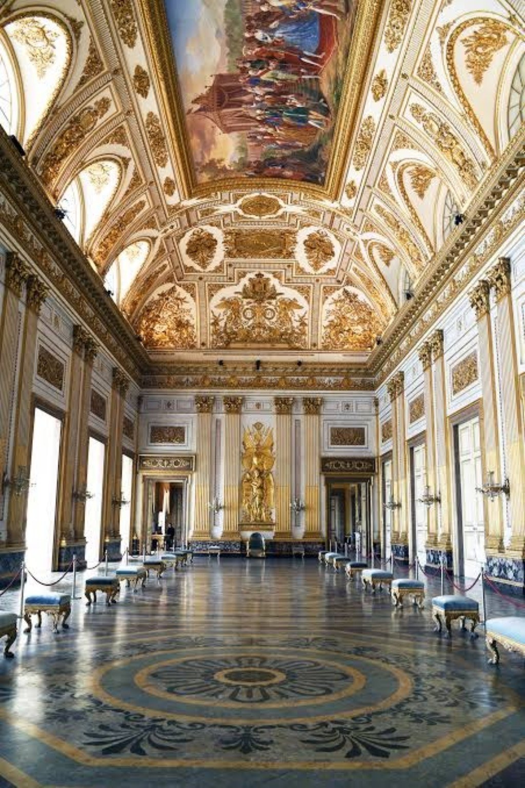 Salón histórico con frescos, molduras doradas y suelo decorado