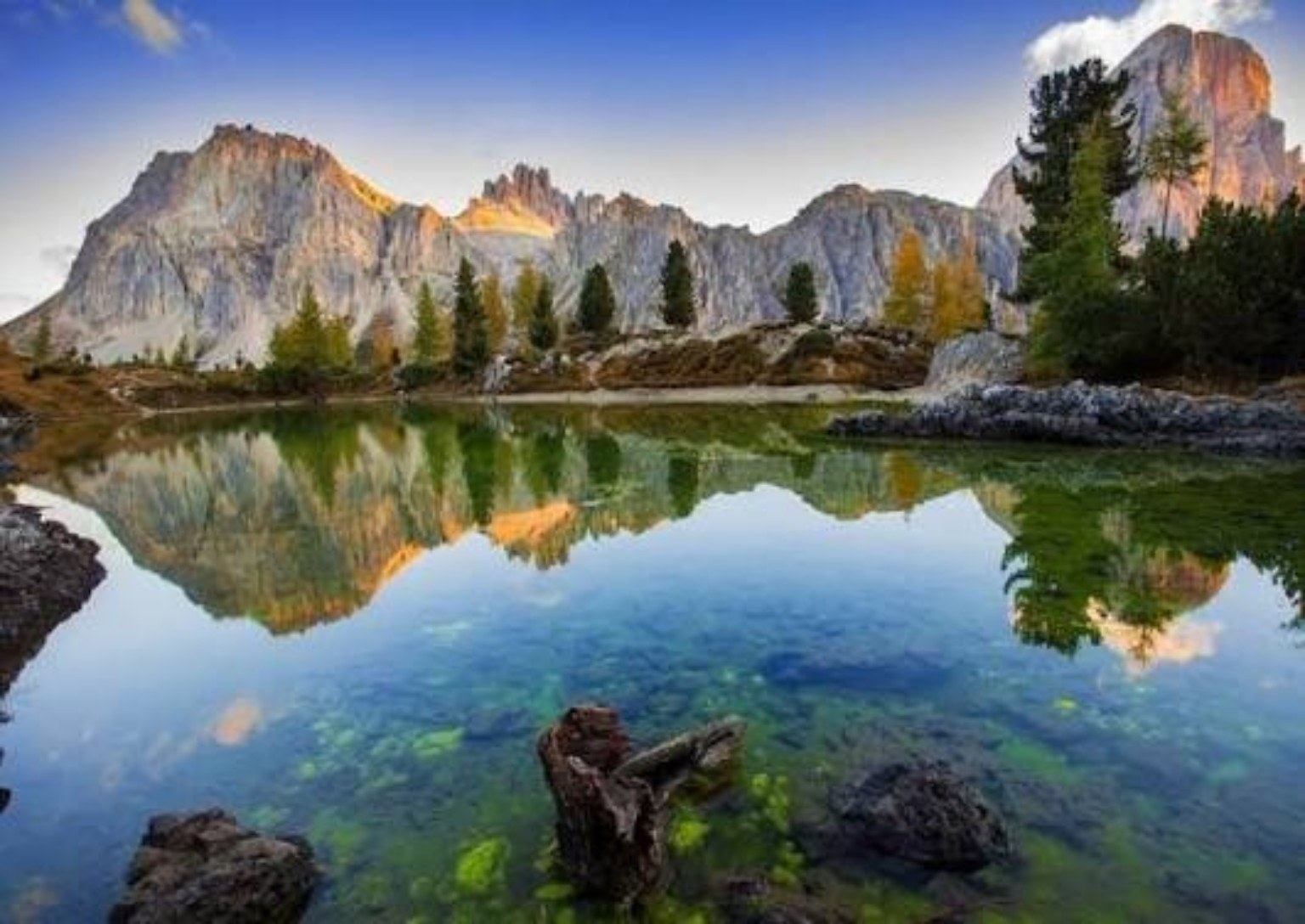 Montañas y árboles reflejados en un lago